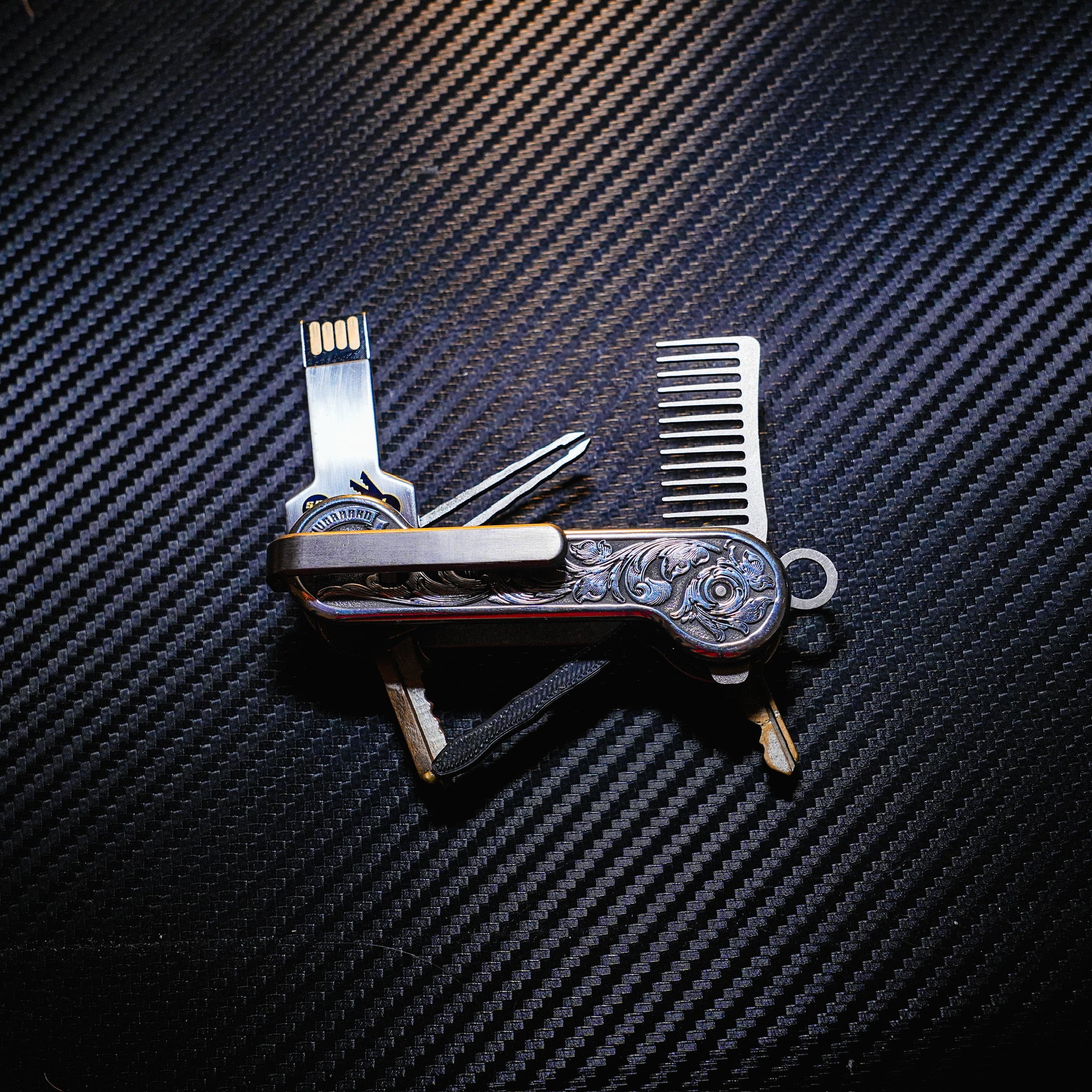 Aluminum Engraverhand with titanium deep carry pocket clip, titanium comb and tweezers, 3D pen body with pen insert, and flash drive.