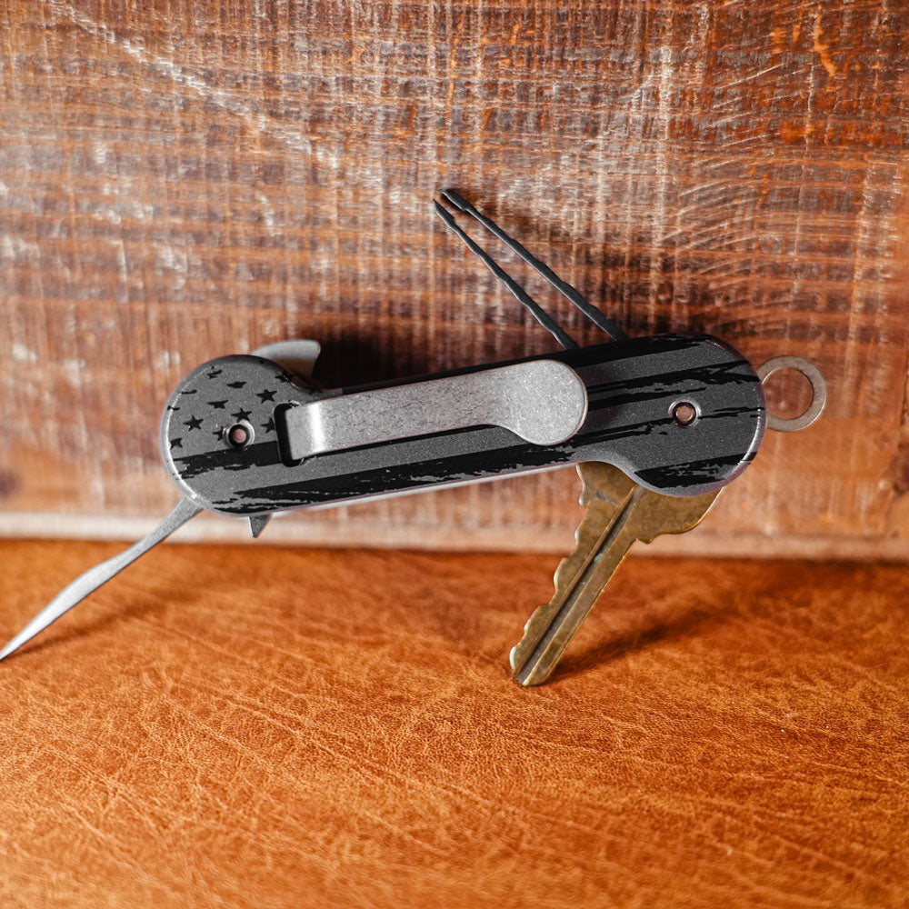 Black-and-Gray-Flag-Aluminum-UV-Printed-KeyBar-Key-and-Tool-Holder-open-back-with-titanium-pick-and-tweezers-and-aluminum-quick-key-tab