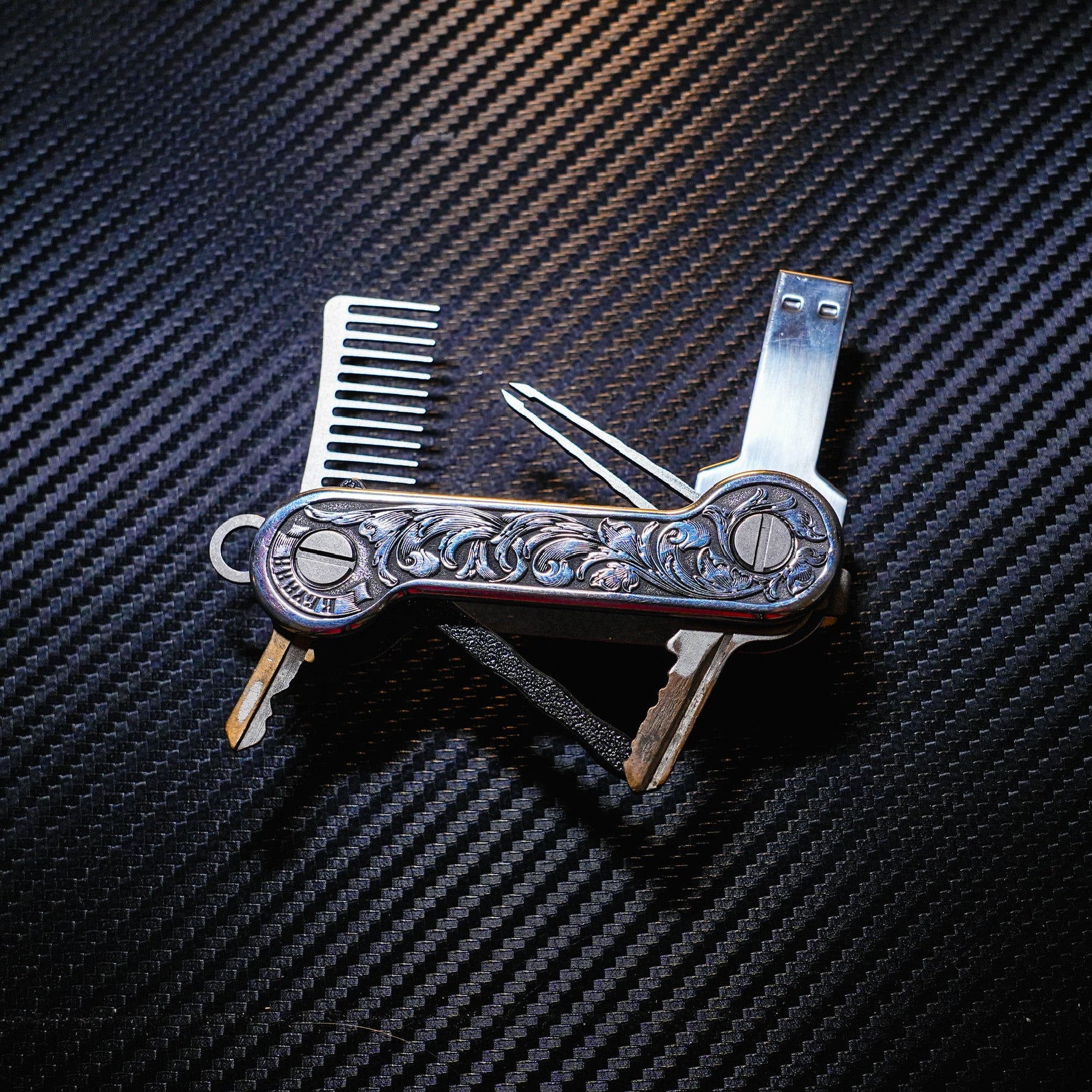 Aluminum Engraverhand KeyBar Key and Tool Holder with titanium beard comb and tweezers, flashdriver, and 3D printed body with pen insert.