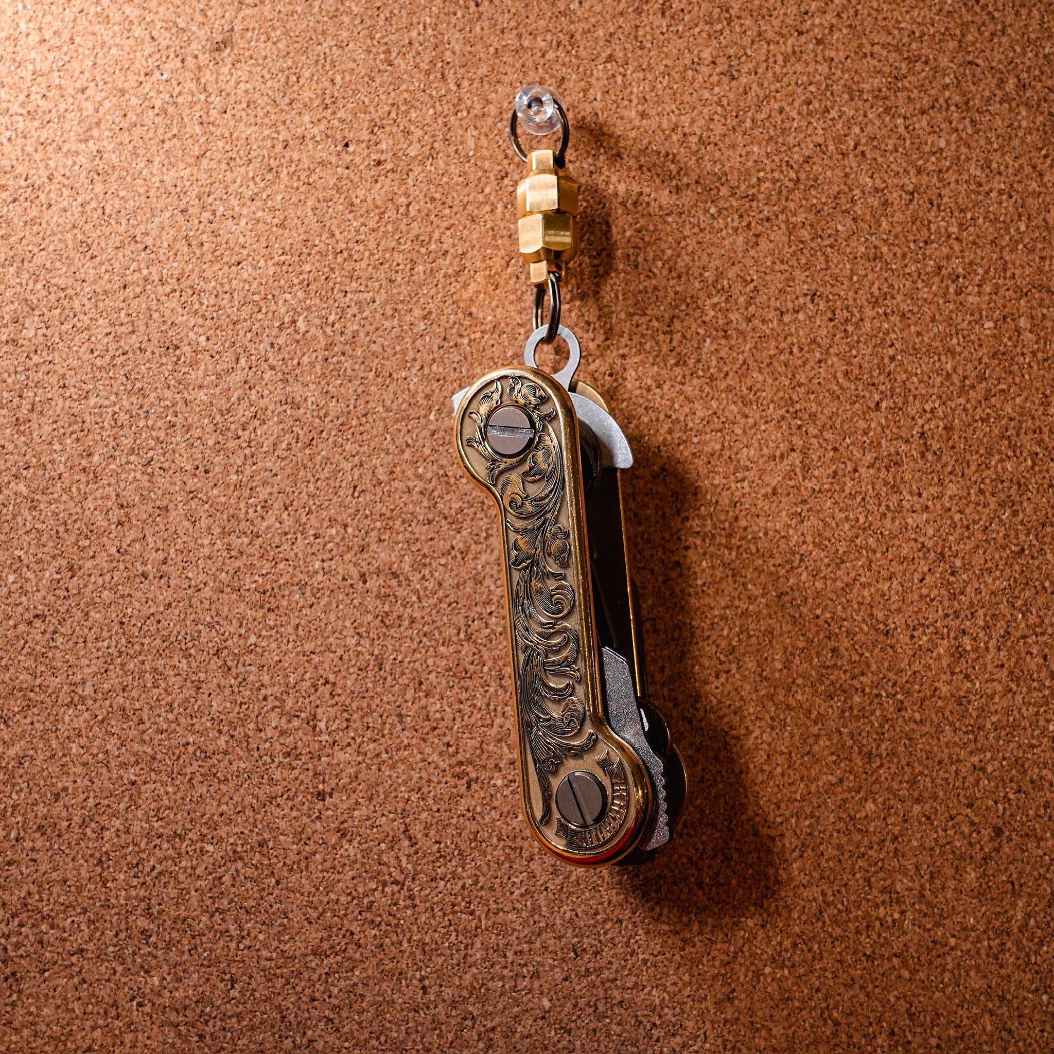 Brass Engraverhand closed hanging on Brass Magnuts