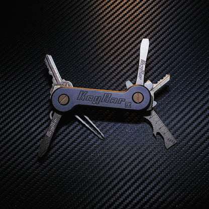 Midnight Titanium KeyBar Key Holder open front with titanium flathead screwdriver, phillips head screwdriver, multi-tool and tweezers, and aluminum quick key tab.