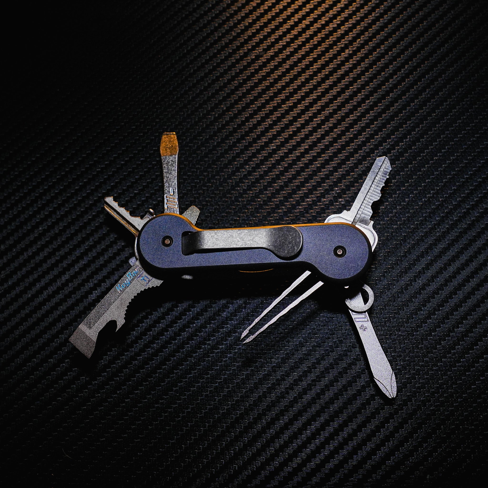 Midnight Titanium KeyBar Key and Tool Holder open back with standard titanium pocket clip, phillips head screwdriver, flathead screwdriver, tweezers, key fob link, and multi-tool.