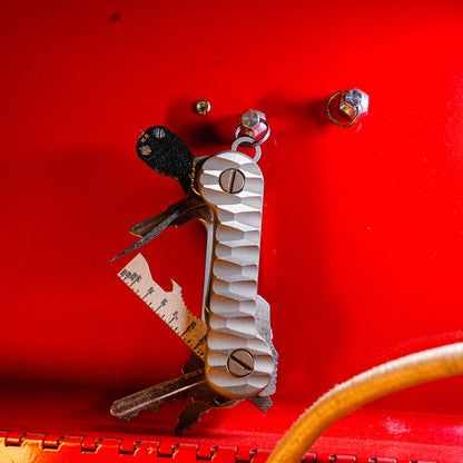 Slayer_Titanium_KeyBar_Key_and_Tool_Organizer_with_standard_titanium_pocket_clip_open_front_hanging_on_magnut_with_flashlight_multi-tool_and_pick